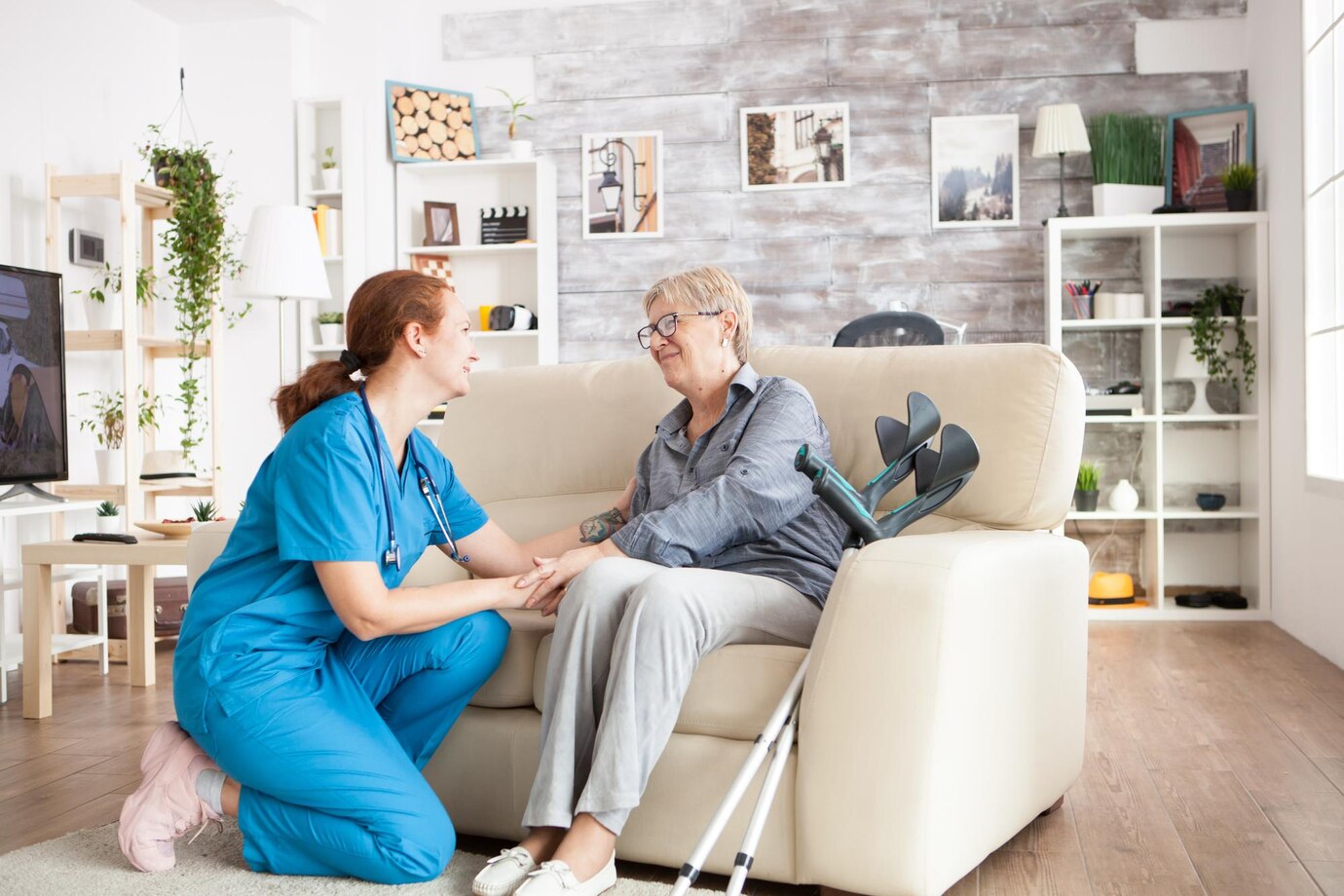 Support worker checking in on elderly participant with crutches relaxing at home, ThriveWell Care personal care and in-home support Melbourne